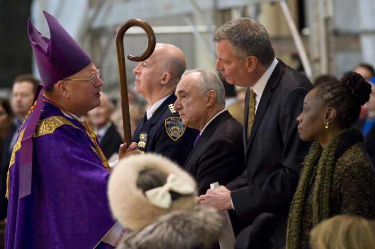 Mayor de Blasio, flanked by First Lady Chirlane McCray and Police Commissioner Bill Bratton and greeting Archbishop Timothy Dolan, attends Mass at St. Patrick's Cathedral the morning after the execution-style killing of two police officers.