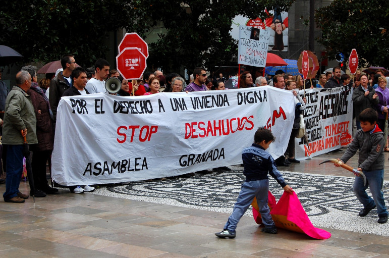 A protest against foreclosures in Spain shares space with a party for a local bullfighting school.