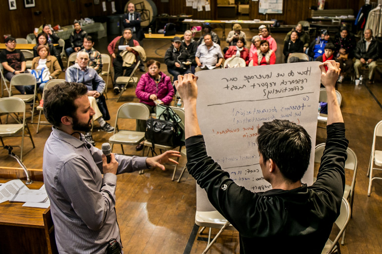 Andrew Hausermann, director of organizing at Faith in New York, speaks as James Hong, director of civic engagement at the MinKwon Center for Community Action assists at a meeting of the Flushing Rezoning Community Alliance in mid-April.