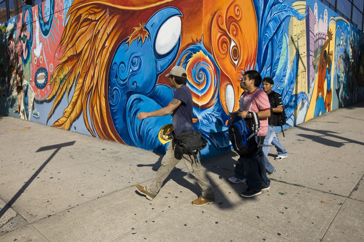 People walk passed a mural near a high school in Bushwick, New York. Photo by J. Silberberg contact: jacobsilberberg@yahoo.com 617-413-8659
