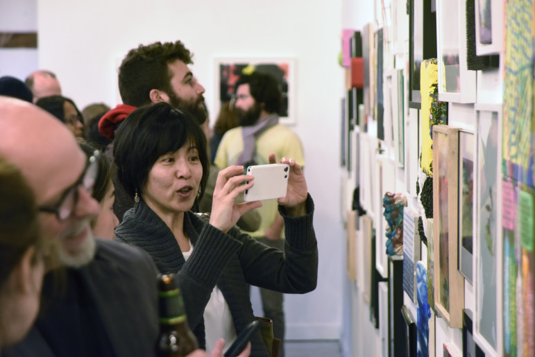 Patrons view artwork at Making History Exhibition and AiB 2015 Benefit, taking place at Storefront Ten Eyck Gallery, April 2015.