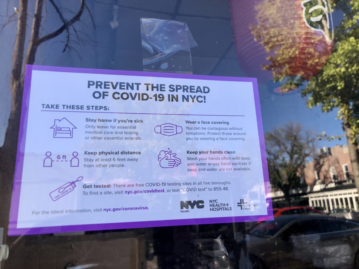 A sign in a Queens restaurant window urging New Yorkers to take COVID-19 precautions.