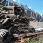 debris piled up outside of flooded homes in Queens