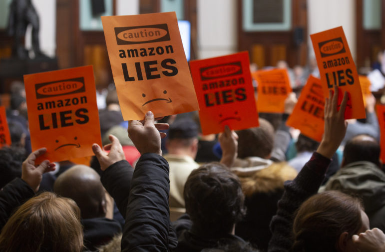 Protest signs against Amazon at a NYC Council hearing in 2019