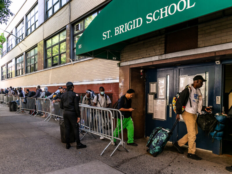 Migrants lined up to reapply for shelter outside St Brigid's School